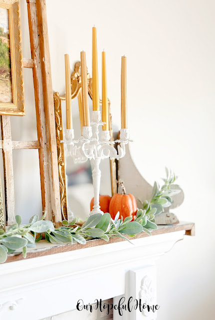 candelabra on mantel with pumpkin and lams ear garland.