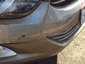 Scratched bumper before collision repairs at Almost Everything Auto Body.