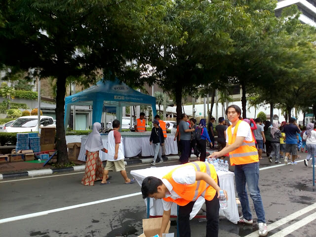 Panitia menyiapkan air minum bagi peserta lari