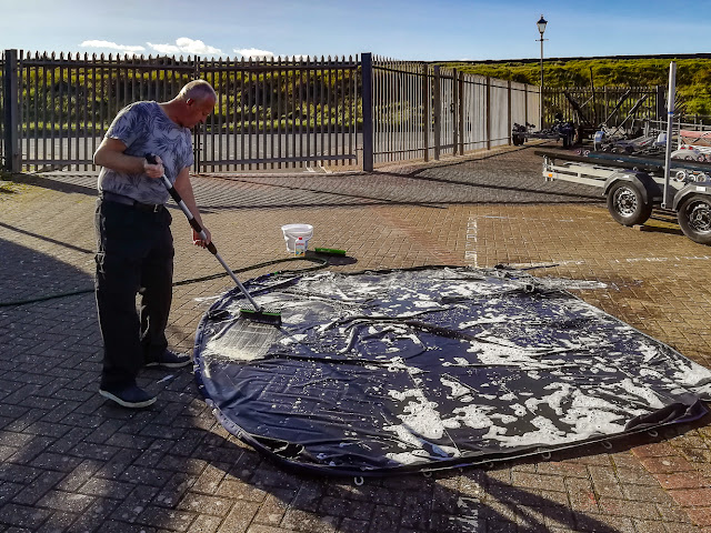 Photo of Phil scrubbing Ravensdale's flybridge cover