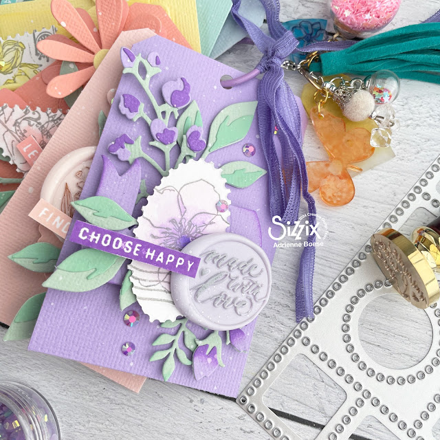 Mini album made of small tags; decorated with the Eileen Hull Faux Postage die, banner and floral dies, white paint splatters, wax seals and Distress Inks.