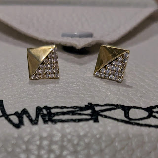 two square gold-plated pave crystal earrings sit on a jewelry pouch that says Ambrosia on it