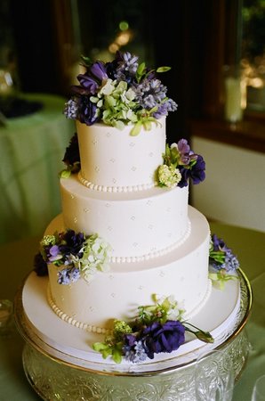 Topped with bouquetcoordinating flowers of green and purple 