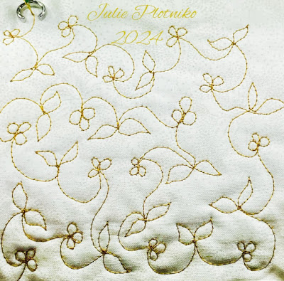 Machine stitching of gold thread on white fabric