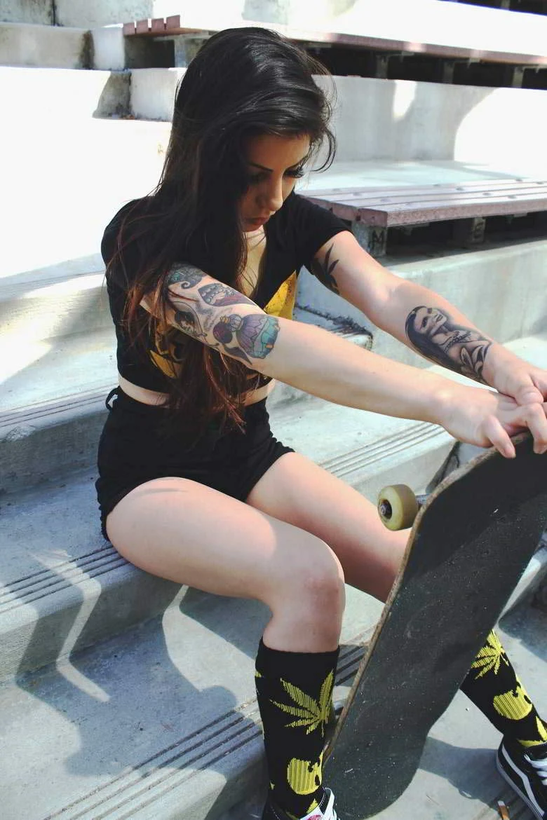 Imagen de chica tatuada con skate