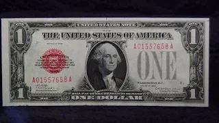 A dollar bill with a red stamp that says “Default”