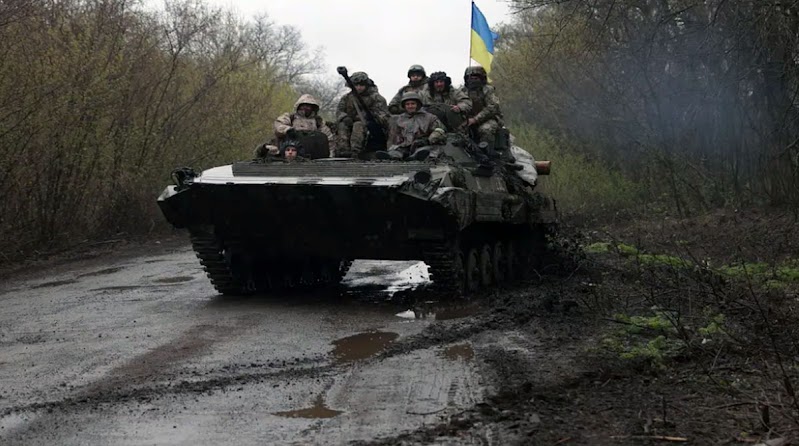 Near Kharkiv, Ukrainian troops ride in an armored personnel carrier.