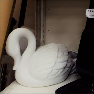 Ceramic lamp in the shape of a swan on an op-shop shelf