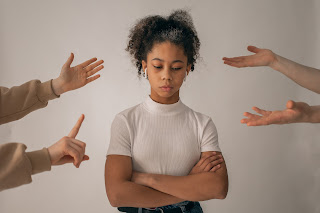 A photograph of a sad girls with hands of other people streching out to her - Kasha's Pen