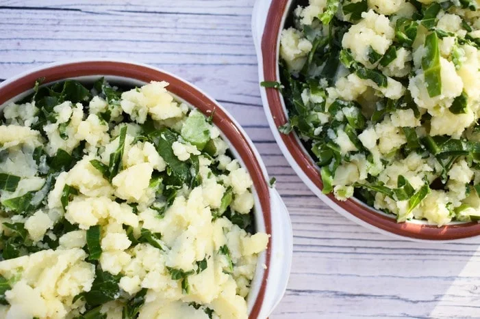 Spring greens mashed potato piled onto individual sausage bakes