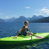 Girl looking at the mountains in her green kayak