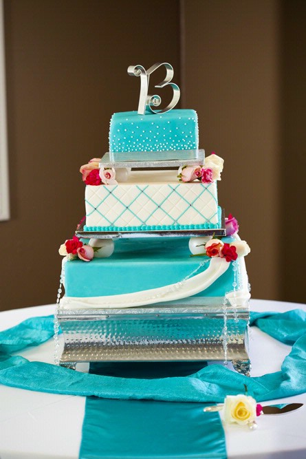 Square turquoise and white cake with red flower accents