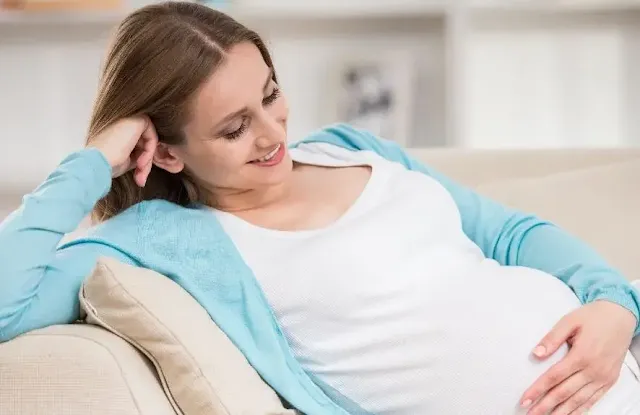 A Happy Pregnant Woman Laying on Sofa