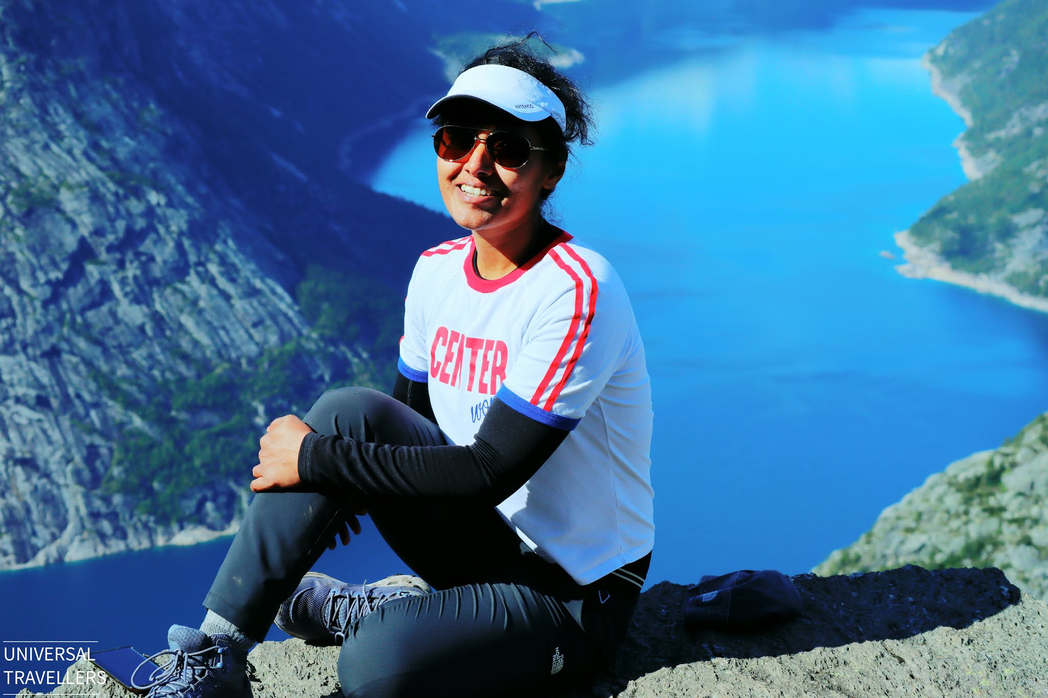 Girl sitting beside trolltunga cliff, norway above Lake Ringedalsvatnet