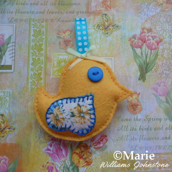 Bright yellow felt bird Spring Easter chick design with blue accents on a floral background craftymarie craft