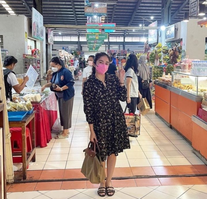 Gaya Ussy Sulistiawaty saat berbelanja di pasar tradisional. [Instagram]