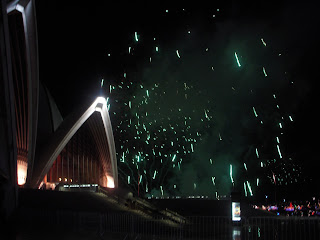 Fireworks bursting behind Sydney Opera House at New Year