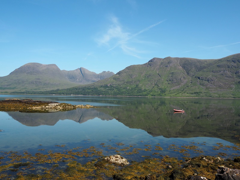 The Torridon hills against a blue sky, reflected in the loch