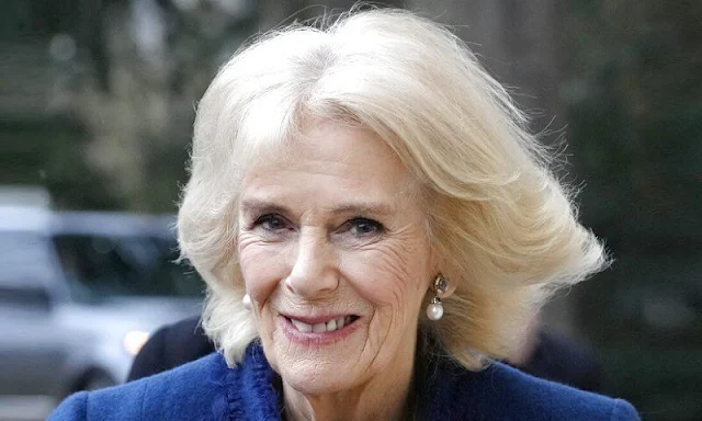 Queen Camilla wore a navy blue midi dress and navy blue wool coat. Pearls earring and black suede boots. King Charles
