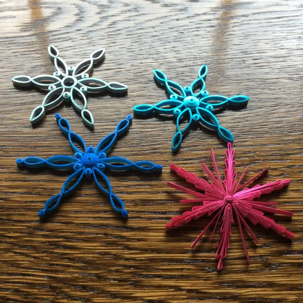 four modern metallic edge quilled snowflakes