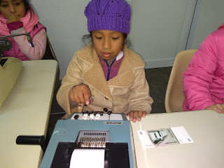 se observa una alumna usando una vieja computadora