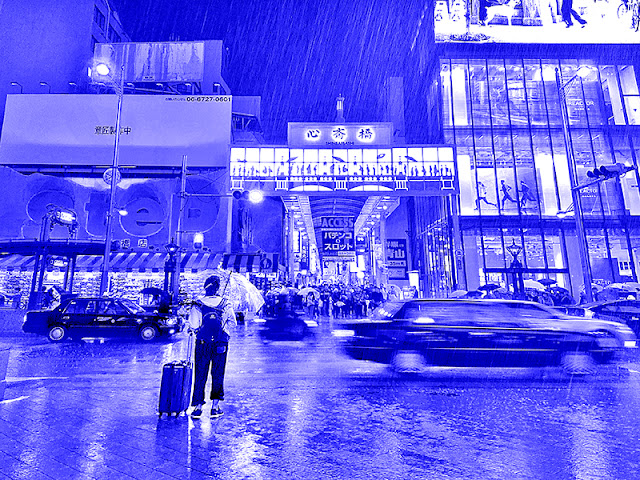 Traveler caught in the rain at Midōsuji shopping street, with suitcase