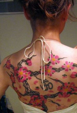  this cherry blossom tattoo apart is the Hindu “Om” symbol in the center.