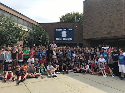 This image shows our current 8th Grade class at Swampscott Middle School gathered outside in front of the building. The students are celebrating the new home of the Big Blue sign.  