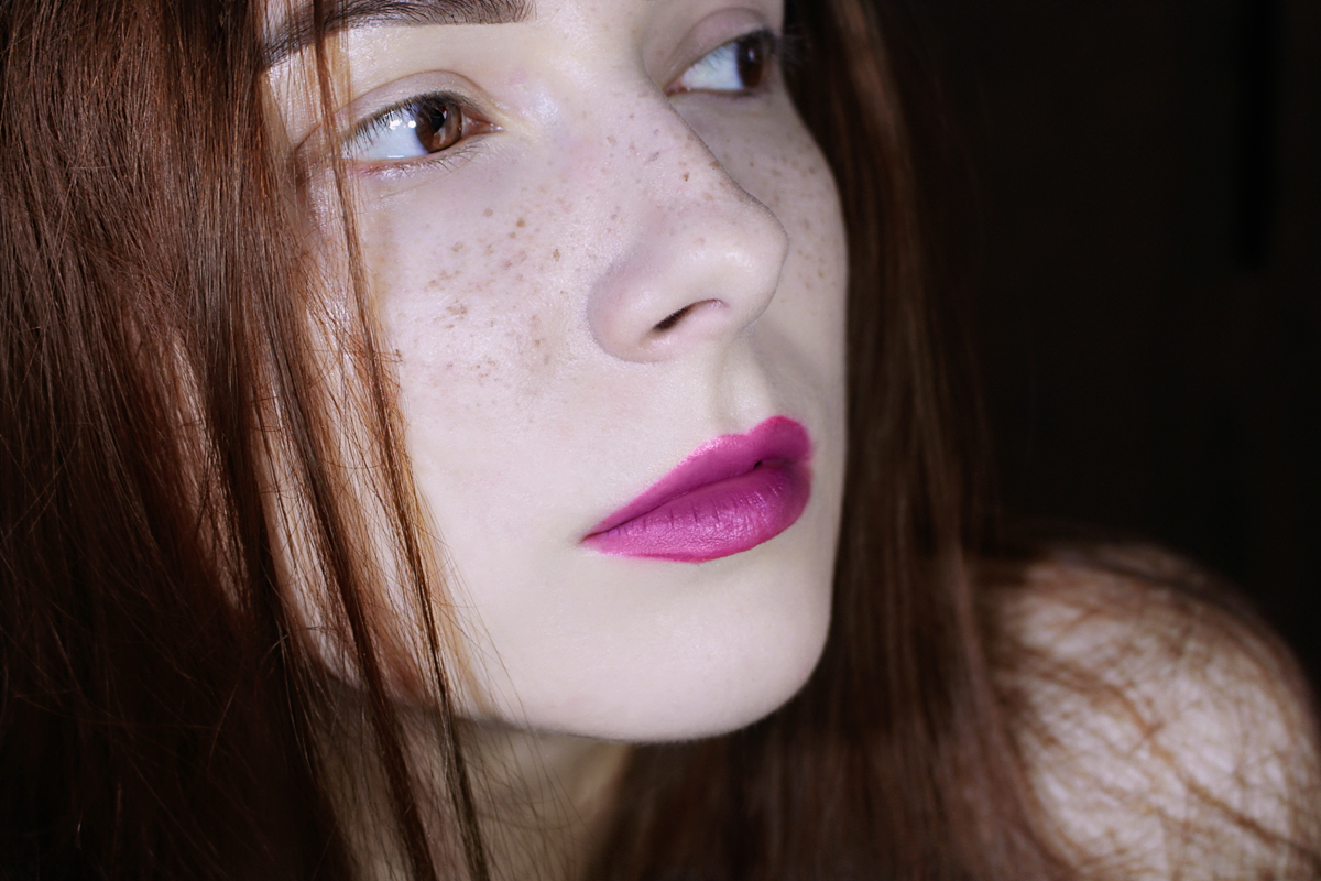 close-up portrait of ginger woman with faux freckles on her face