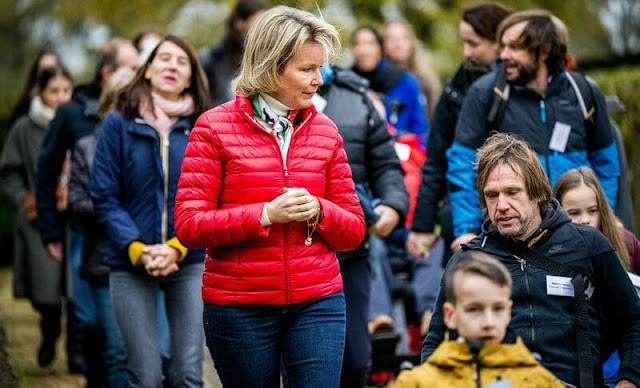 Queen Mathilde wore a red puffer jacket and she wore navy denim jeans pants. Crown Princess Elisabeth