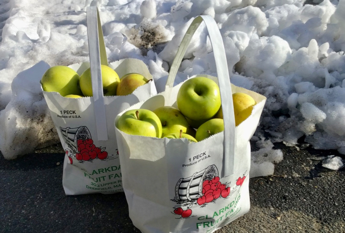 Two one-peck paper bags full of yellow-green apples