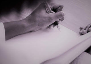 Black and white photo of woman writing in notebook