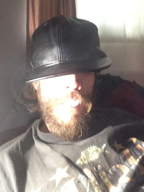 OLB with full copper beard and black leather hat and smoke pouring from