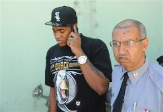 why is this idiot wearing a White Sox hat?  We pay his salary, shouldn't he at least be escorted to prison in a Mets hat?