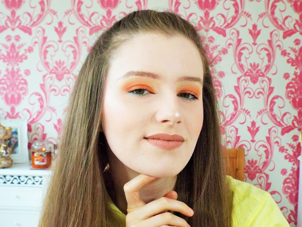 Pumpkin pie themed makeup look, featuring a matte orange eyeshadow look on the lid, green eyeshadow on lower lash line, paired with nude pink liquid lipstick