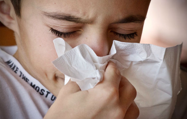 Bambino che si soffia il naso per il raffreddore