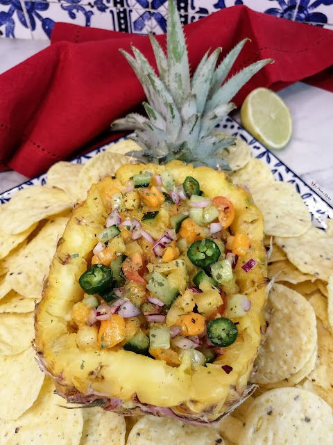 Pineapple and Mango Salsa, pineapple salsa, mango salsa, salsa, pineapple bowl, pineapple serving bowl, how to turn a pineapple into a serving bowl, salsa and chips, wraps, salad, vegan, salsa recipe, tiktok food, pinterest food, pineapple, mango, cucumbers, tomato, limes, quick recipe, summer recipe, snack, food, food blog, food blogger, food photography, food flatlay, mango, fruit, spicy food, spicy fusion kitchen