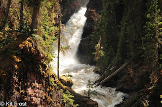 Beautiful light falling on an early spring waterfall, water gushing through a break in the rocks.