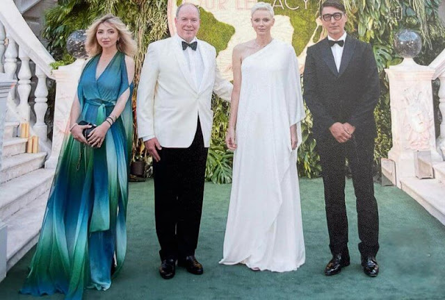 Princess Charlene wore a Sylvie jersey one-shoulder cape sleeve gown by Halston. Diamona necklace and Dior diamond earrings