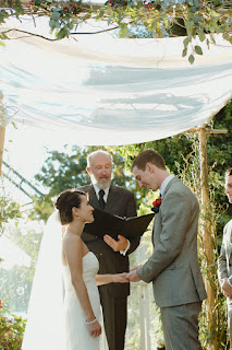 Kent Buttars, Seattle Wedding Officiant, watches as Jon places the wedding ring on Juanita's hand 