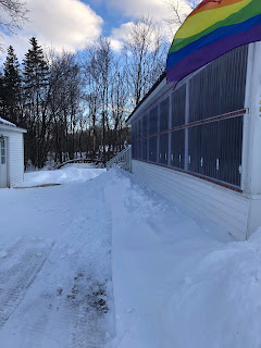 View of Porch, Snow Piles and Waving Rainbow Flag