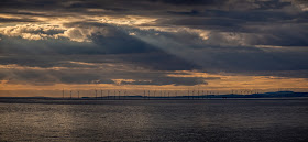 Photo of light breaking through the clouds over Robin Rigg Wind Farm in the Solway Firth