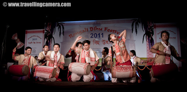 Huchori Performance by an Assamese group of boys @ Rongali Bihu Festival, IGNCA, Delhi : Posted by VJ SHARMA on www.travellingcamera.com : Huchori - Huchori is an integral part of Rongali Bihu. Choral parties of singers and dancers moving from house to house is a salient feature of Rongali Bihu !!!Huchori is a regular thing which happens during the Rongali Bihu and it is a custom of community singing in which a group of singers visit each home in their locality and sing songs containing spiritual and moral values. The group comprises only of men and the event coincides with the Assamese New Year. The group visits every house irrespective of caste, creed and social status of the householder. During the reign of the Ahom dynasty, Huchori singing was a usual custom in the royal palaces. At a later period it began to be practiced by common people.A group of boys performed Hichuri on the stage and it was really interesting to see overall getup of folks in the groups and it seems elder folks also join this group to better guide the younger ones :) .. Although I was not able to make any sense out of the songs or dialogs, but it looked very interesting !!!Huchori group begins its procession from the village headman’s house and continue towards the other houses in the vicinity. The procession proceeds amidst chanting, singing and dancing. Visiting each house in the village, the group accepts some donation from the residents. The singers usually carry a staff, a bag, an umbrella and a lamp while roaming around the village. Their instruments comprise of dhol (drum), taal (cymbals), pepa (horn pipe) and taka (bamboo clapper).This seems more like Lohri in North India.. Specially in Punjab and Himachal Pradesh !!! On Lohri week, boys make some groups and start visiting various houses in the village/town and sing different Lohri Songs... After that every house master offer some stuff like wheat, corns or rice.. and now people prefer to give money.. as it's convenient for both parties :)Huchori Performance at Rongali Bihu Festival in Indira Gandhi National Center of Arts was amazing and the energy level of folks performing was commendable !!!Here is one of the most enthusiatic performer of Hichori Dance who was handling dhol during Riganli Bihu in Delhi !!!Notice the dressed of all these folks and they have taken proper care of clothings they should use !!!Although I was not able to make out anything as they were singing in Assamese but their expressions were telling a story !! Here a couple is presenting something for god and praying for good !This whole event was organized by Assam association Delhi in partnership with Indira gandhi National Center of Art and it was wonderful experience at Rongali bihu festival !!!