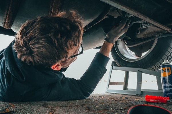 man fixing his vehicle