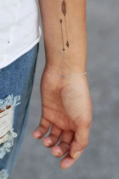 vemos a una mujer joven con un tatuaje pequeño, el tatuaje es de estilo hipster