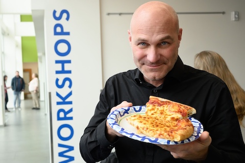 The dean holding a plate of pizza