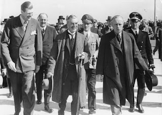 Chamberlain, con sombrero y paragua, camina con el ministro del exterior alemán von Ribbentrop (a la derecha) y von Dornberg (a la izquierda). Berchtesgaden meeting, 1938