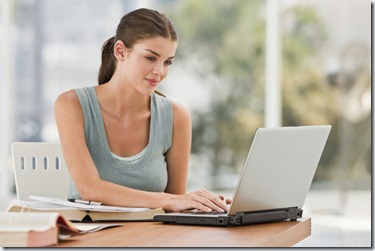 Beautiful young woman using laptop and smiling