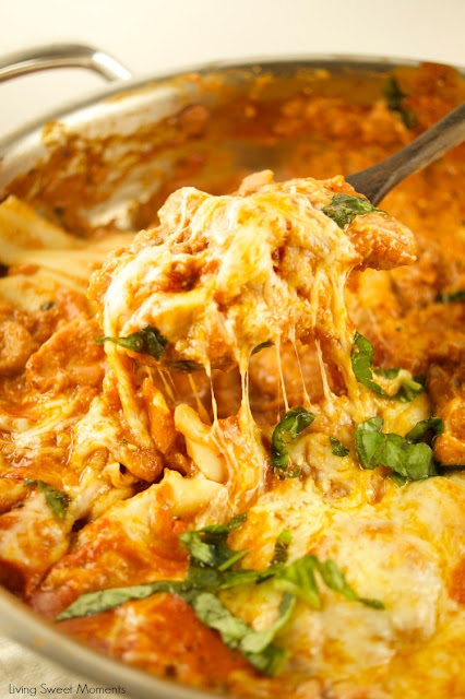 Spoon lifting cheesy one pot chicken lasagne from a dish