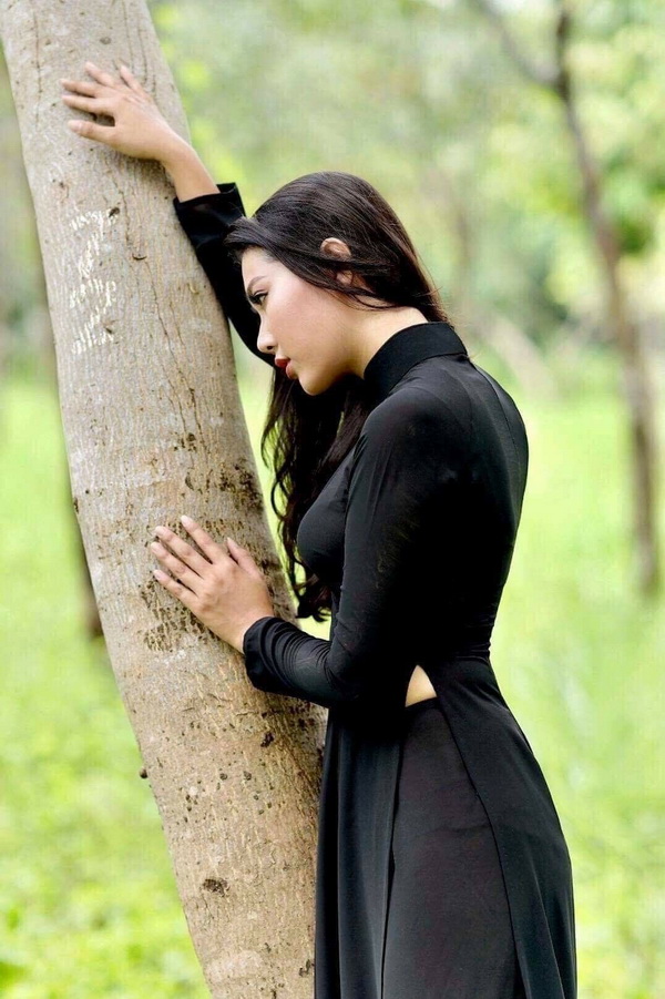Thiếu nữ áo dài đen dựa gốc cây